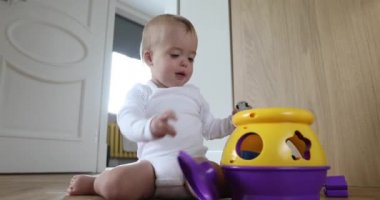 Şirin bebek katta oturan renkli oyuncakla oynamak