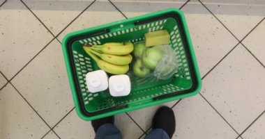 Bakkal ya da süpermarket gıda sepeti kadınla