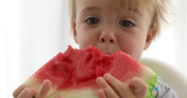 Niño comiendo sandía en la mesa — Vídeos de Stock