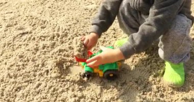 Raod oynayan çocuk oyuncak excavatorin kum ile çalışır
