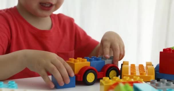Closeup childs χέρια παίζουν πολύχρωμο πλαστικό τούβλα — Αρχείο Βίντεο