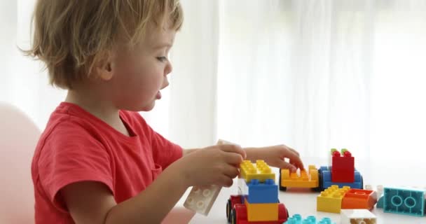 Primer plano niños manos jugar coloridos ladrillos de plástico — Vídeos de Stock