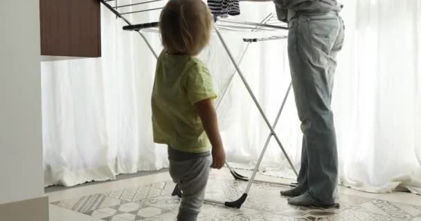 Pequeño niño ayudando a colgar la ropa de su madre — Vídeos de Stock