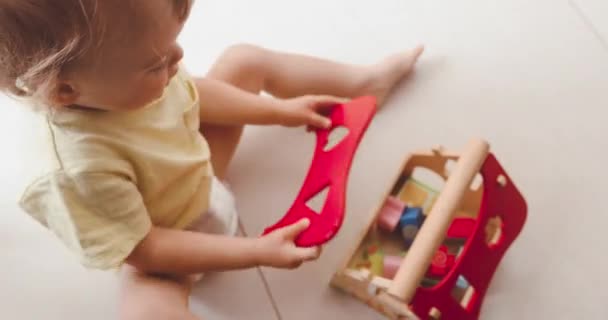 Schattige kleine babyjongen spelen met klein houten huis — Stockvideo