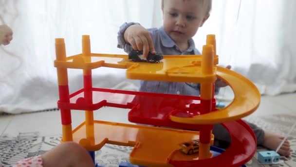 Gelukkige jonge geitjes spelen met speelgoed auto's op verdieping — Stockvideo
