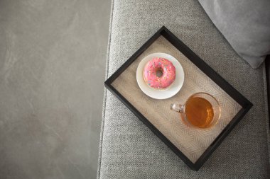 Fincan çay ve çörek tepsisi üzerinde