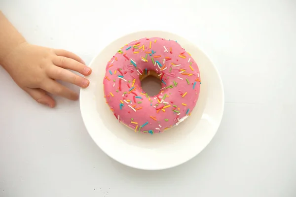 Mão de colheita de criança perto de donut — Fotografia de Stock