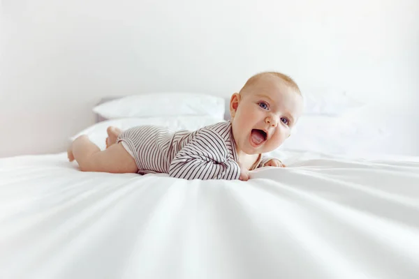 白いベッドの上の魅力的な幸せな赤ちゃん — ストック写真
