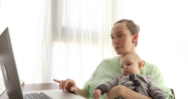 Vrouw met baby met behulp van laptop — Stockvideo