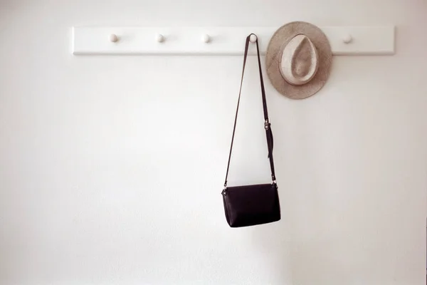 Hat and bag hanging on pegs — Stock Photo, Image