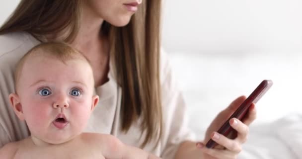 Mother with little daughter uses smartphone — Stock Video
