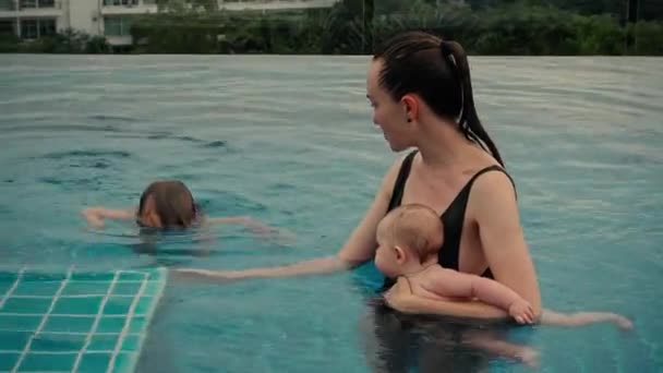 Mujer con niños en la piscina — Vídeo de stock