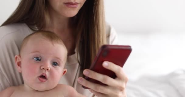 Mutter mit kleiner Tochter nutzt Smartphone — Stockvideo