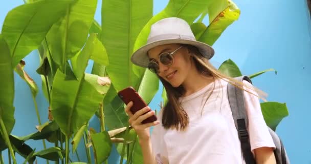 Emocionado joven mujer de vacaciones utiliza el teléfono inteligente — Vídeo de stock