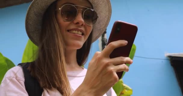 Nadšený mladá žena na dovolené používá smartphone — Stock video