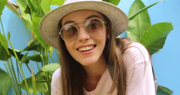 Ελκυστική χαμογελώντας νεαρή γυναίκα σε γυαλιά κοντά φυτά — Αρχείο Βίντεο