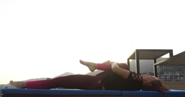 Donna che si allena, allungando la gamba sdraiata sul tappeto — Video Stock