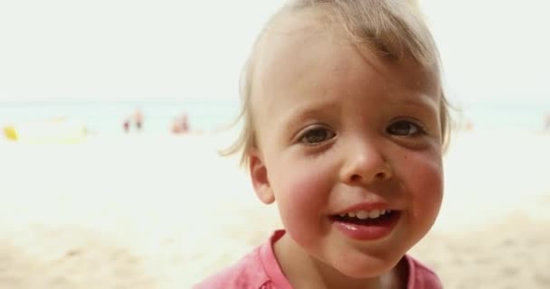 Niño alegre de pie en la playa — Vídeos de Stock