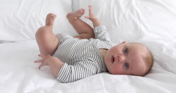 Charming happy baby on white bed — Stock Video