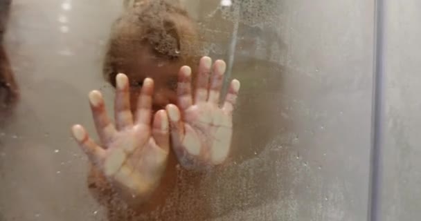 Niño tocando vidrio en el baño — Vídeo de stock