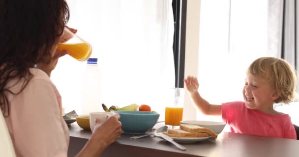 Mãe com crianças tomando café da manhã na cozinha — Vídeo de Stock