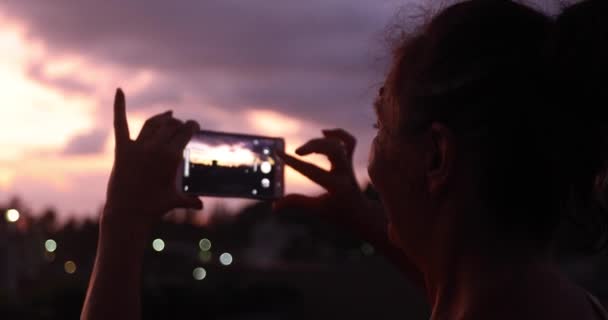 Nő figyelembe fotó napnyugtakor ég — Stock videók