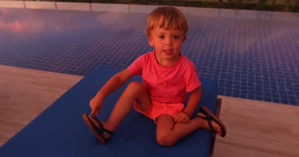 Little boy on poolside in sunset — Stock Video