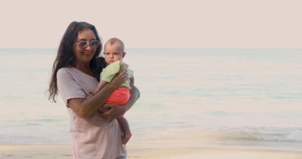 Elderly woman with baby near sea — Stock Video