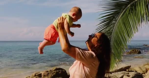 Elderly woman playing with baby on beach — Stock Video