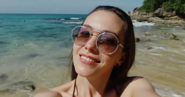Красивая женщина делает селфи с помощью телефона на пляже — стоковое видео