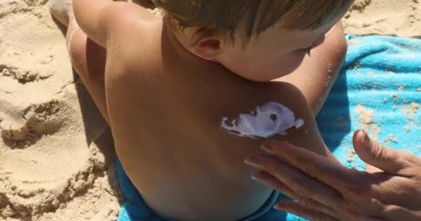 Moeder sunblock room toe te passen op de schouder van het kind — Stockvideo