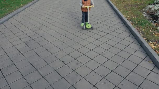 Lustiger Junge auf Roller im Park — Stockvideo