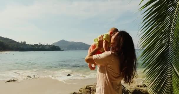 高齢者の女性がビーチで、赤ちゃんと遊ぶこと — ストック動画