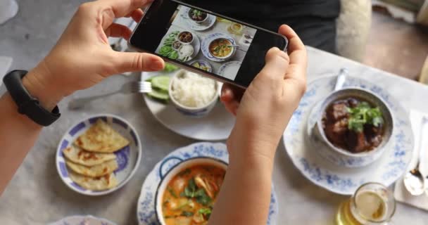 Cortar la mano tomando fotos de la comida en la mesa — Vídeos de Stock