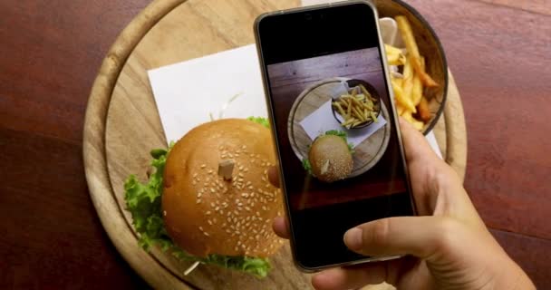 テーブルに食べ物の写真を撮る作物手 — ストック動画