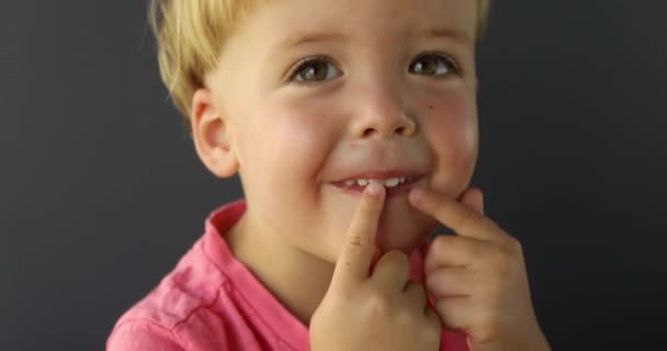 Garçon pointe ses doigts des deux mains sur ses dents — Video