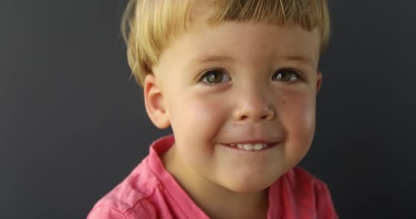 Young boy looks at the camera and smiling — Stock Video