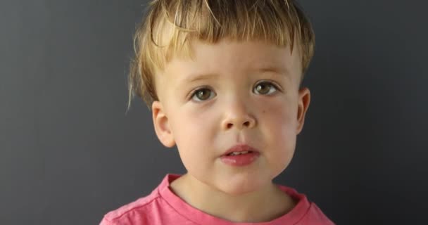 Bedårande glad pojke tittar på kameran — Stockvideo