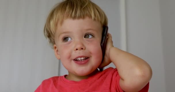 Hareket eden telefon ile oynayan erkek bebek — Stok video