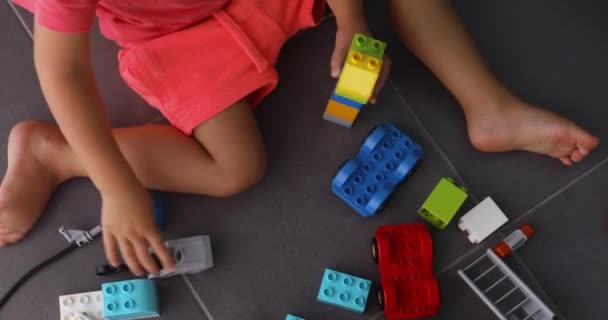 Child playing with lots of colorful plastic blocks indoor — Stock Video