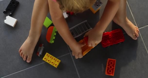 Child playing with lots of colorful plastic blocks indoor — Stock Video