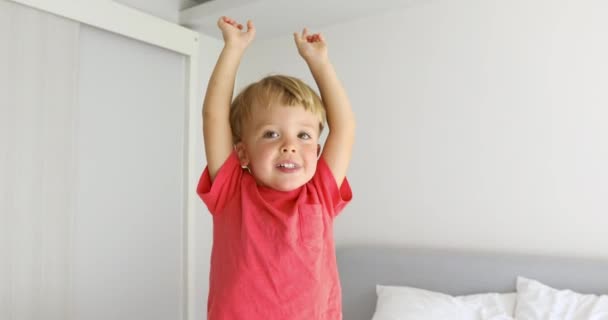 Niño alcanzando el techo con los brazos arriba — Vídeos de Stock