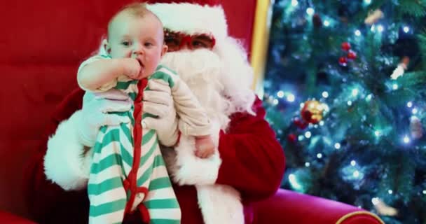 Child and Santa Claus sitting near glowing fir tree — Stock Video