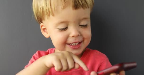 Criança tocando tela do telefone celular, interesse em tecnologia moderna — Vídeo de Stock