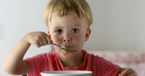 Menino comendo flocos de milho no café da manhã — Vídeo de Stock