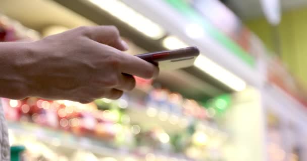 Vrouw jatten Smartphone bij supermarkt — Stockvideo