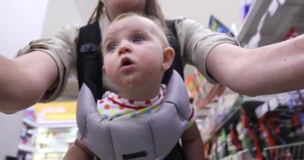 Žena s vozíkem chodí kolem obchodu s dítětem — Stock video