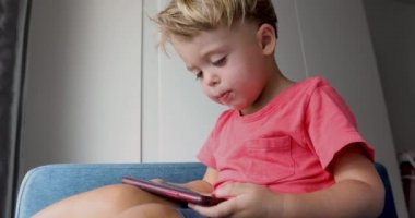 İçerik çocuk kanepede akıllı telefon oynuyor