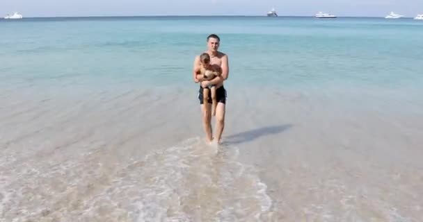 Man med pojke som går på stranden — Stockvideo