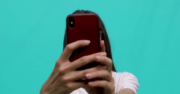 Woman with smartphone taking selfie on blue background — Stock Video